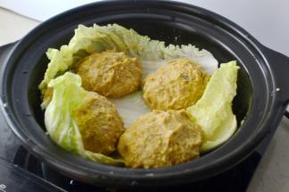 将肉酱分四份，在手上左右摔打上劲后放在叶子上