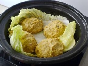 将肉酱分四份，在手上左右摔打上劲后放在叶子上