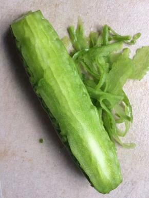 苦瓜洗净后，用刨丝器慢慢刮擦表皮，知道看见白瓤后停下
