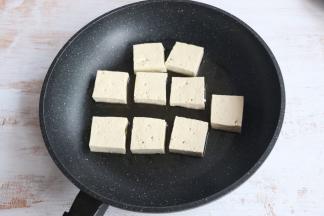 平底煎锅内，倒入适量食用油。
放入豆腐块，小火煎制。