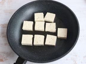 平底煎锅内，倒入适量食用油。
放入豆腐块，小火煎制。