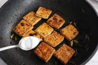 翻炒至豆腐充分裹上香辣酱。
撒少许盐调味。