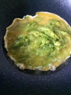 锅中热油，倒入苦瓜蛋液