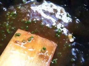 锅中热油，调好酱汁，加入三分之一的香葱，浇在蒸好的豆腐上即可