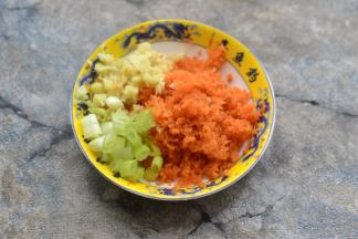 将胡萝卜去皮用擦丝器擦成蓉，姜也同样处理，香葱切颗粒