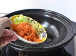 砂锅烧热加入适量的油然后将葱姜和胡萝卜蓉放入翻炒均匀