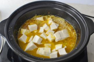 加入适量清水然后将嫩豆腐用小刀在手上割小块放入