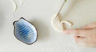 整出天鹅的长脖子，及捏出嘴巴。再用刀子，如图，压出翅膀。