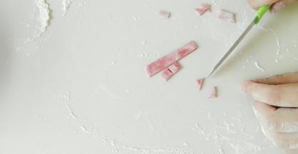 取部分白面团，加入适量红曲米粉，切出正方形，在切出三角形。