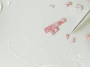 取部分白面团，加入适量红曲米粉，切出正方形，在切出三角形。