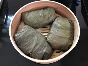 用荷叶把糯米饭包好码入蒸笼。