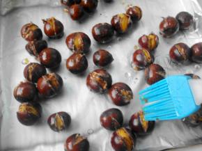 拿出烤开壳的栗子，刷上糖桂花，开口处可多刷一点；再入烤箱烤5分钟就好啦