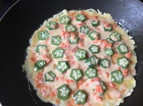 锅里热油倒入鸡蛋糊，快速码上秋葵，也可以把秋葵直接混合鸡蛋糊里面，两面煎熟即可