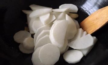 将白萝卜放入锅中翻炒片刻