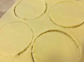 取出冷藏变硬的面团，擀至0.5厘米左右厚的薄片，用慕斯圈裁成一个个圆形，放入冰箱冷冻