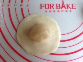 将水油皮擀成圆形，旁边薄中间厚，将油酥放在中间。收口，捏紧，收口朝下，盖保鲜膜，松驰15分钟