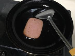 玉米油放入平底锅，将油烧入8分熟，开小火，放入火腿片煎