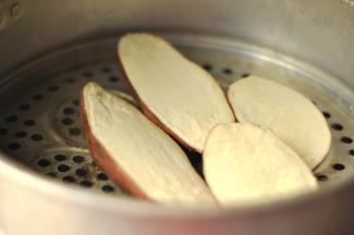 2、白薯清洗干净后，对半切开上锅蒸熟