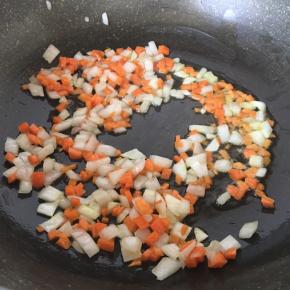 冷锅放半汤匙橄榄油，锅热后放入胡萝卜丁和洋葱丁翻炒出香味