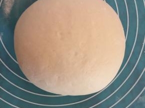 接着取出面团后加入面粉继续手揉排气