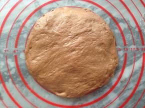 将静置后的面团，光滑的上面朝下，用手压成圆形，大小就按揉面垫上5寸大小即可