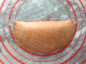 将上部分向下折叠，折成半圆形，边缘捏紧