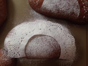 发酵好的面包坯取出，花边纸裁成一半，中间剪空，放在面包坯上，在上面过筛一些面粉