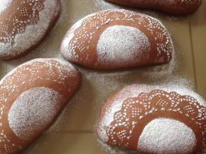 将花边纸小心提起，不要让纸上的面粉漏下去。这样，面包坯上就会有漂亮的图案了