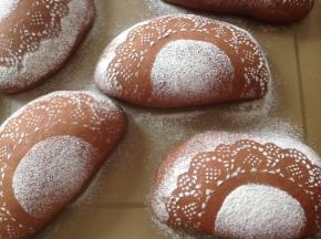 将花边纸小心提起，不要让纸上的面粉漏下去。这样，面包坯上就会有漂亮的图案了