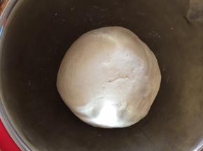 开启面包机自助和面功能进行和面。面包机和面后将面团取出，揉成光滑面团