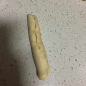 醒发好的面团擀成椭圆形，然后卷起来收口捏紧