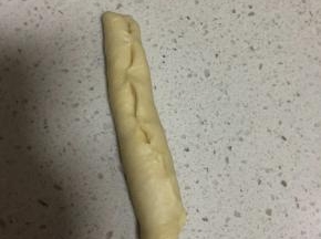 醒发好的面团擀成椭圆形，然后卷起来收口捏紧