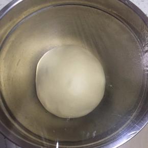 把面团滚圆，盖保鲜膜发酵至两倍大。（也可以面包机中直接发酵）