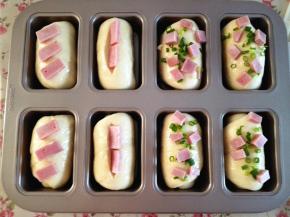 11.	在刷好蛋液的面包上，撒上香葱，摆上火腿，