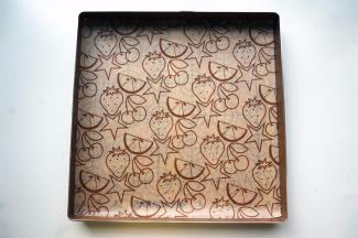 将带图案的吸油纸放入烤盘。