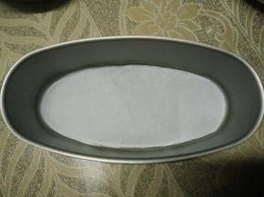 在椭圆固底不粘模具底部垫上油纸，内壁就不用抹油撒粉了，因为是不粘模，（我是怕不好脱模所以在底下垫油纸，方便脱模。）如果你用的是活底的模具，就要在模具外面包上锡纸，以防渗漏和水汽进入。