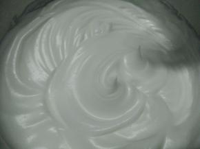 蛋白里面滴入几滴柠檬汁或白醋，再加细砂糖打发至湿性发泡，约八分发，如图。