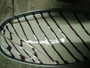 将装有红曲糊的裱花袋头部剪个小口，在蛋糕糊表面斜拉出线条，再用牙签对角线来回斜拉。