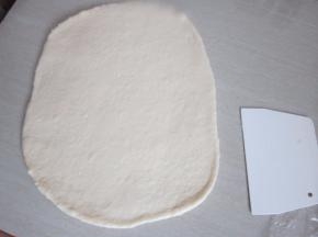 发好的面团排气并将面团擀成长方形。