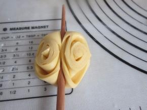 将三角尖朝上用筷子在上中按压一下，花形就出来了。