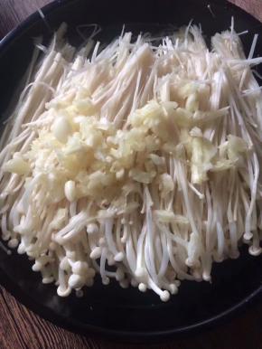 金针菇洗净去蒂，撒上拍碎的蒜末