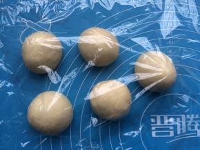 把面团拿出操作台上轻轻排气，分成5等份搓圆，盖上保鲜膜松弛5-10分钟。