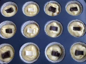 把面糊挤入纸模里一半，把切好的巧克力塞到中间，上面再挤一些面糊。