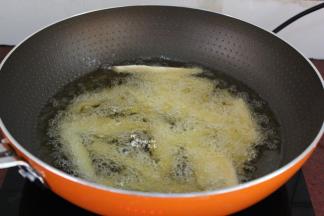 锅中倒入适量的油，油温150度左右，放入薯条；