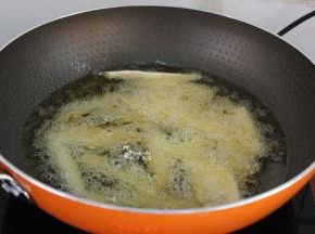锅中倒入适量的油，油温150度左右，放入薯条；