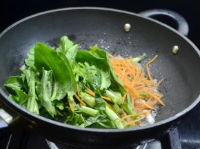 接着将胡萝卜丝和青菜放入翻炒均匀
