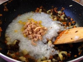 锅里放入煮好的粥，加入一碗玉米粒，加入玉米火腿丁小火慢炖