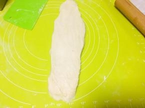 取一份面团用擀面杖擀成长条，之后卷起来，擀面杖可以裹一层干粉更好操作