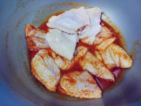 将盐、料酒、奥尔良腌料和水调匀后，倒入鸡翅中拌匀