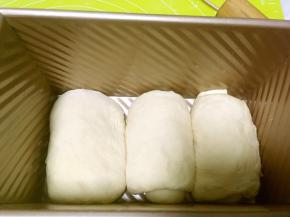 将卷好的面团放入模具内，放烤箱二次发酵，烤箱内放碗热水